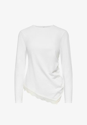 Haut blanc à manches longues avec ourlet asymétrique et bordure en dentelle, avec un léger froncé latéral pour une apparence ajustée.