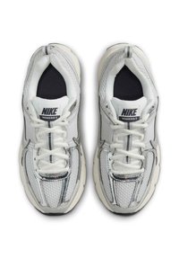 Baskets Nike Vomero 5 en blanc et gris, dotées d'un upper en mesh, d'une languette rembourrée et d'une semelle extérieure texturée avec des accents contrastants.