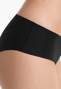 Zwarte hipsterondergoed met een gladde textuur en een elastische tailleband, voorzien van naadloze randen voor een minimalistisch ontwerp.