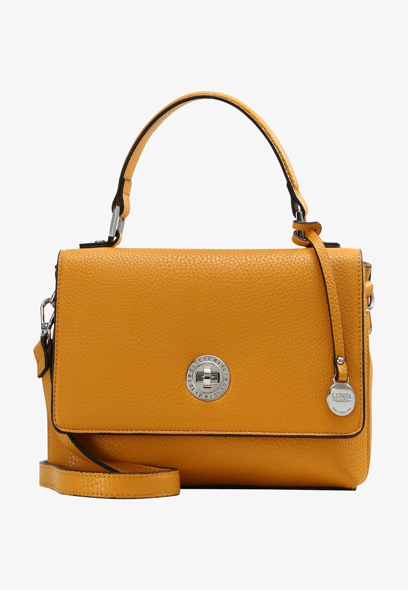 Sac à main en cuir jaune texturé avec poignée supérieure, bandoulière réglable, fermoir tourniquet argenté, et étiquette métallique circulaire de la marque sur le côté.