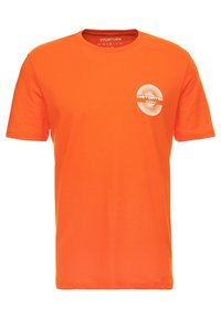 Oranžové tričko s krátkým rukávem vyrobené z bavlny s kulatým výstřihem, které má bílou kulatou grafiku se slovem "DISTORTED."