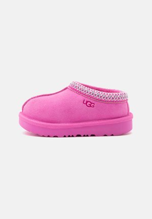 Chausson rose UGG à enfiler avec bordure brodée blanche et rose et semelle texturée, vu de côté sur fond blanc.