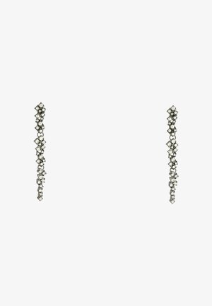 Sidabrinės tonacijos auskarai, puošti nusileidžiančiomis eilių aiškių cirkonio akmenukų formomis, sukuriančiomis linijinį ir tekstūrinį dizainą.