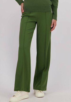 Groene wijde broek met gestructureerde stof, voorzien van verticale naden, een hoge taille en een ontspannen pasvorm, gecombineerd met witte sneakers.