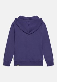 Sudadera con capucha morada de textura suave, con puños y dobladillo acanalados. Incluye una pequeña etiqueta con el logo en la parte inferior izquierda.