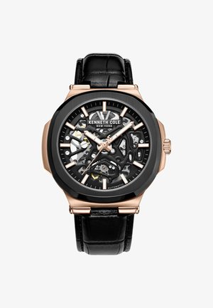 Skeleton automatische horloge met een zwarte wijzerplaat, rose-gouden accenten en een zwarte leren band. Beschikt over een geometrisch ontwerp en zichtbare beweging.