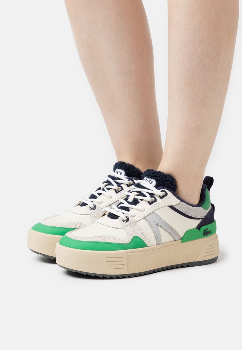 Baskets au design beige et vert, avec un dessus texturé, des accents bleu marine, une épaisse semelle crème et des lacets contrastés.