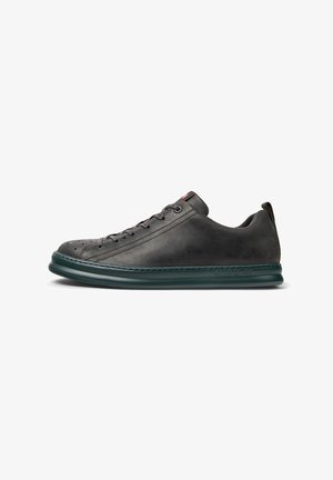 Grå lædersneaker med rund tå, mørkegrøn sål og snørebåndsdesign, der har perforeringer til ventilation og et logo på siden.