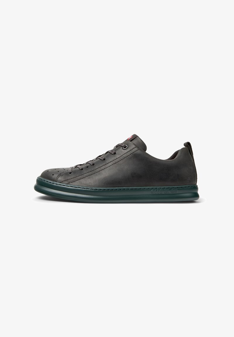 Gray leather sneaker with a rounded toe, dark green sole, and lace-up design, featuring perforations for ventilation and a logo on the side.