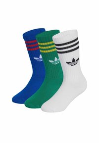 Trzy pary sportowych skarpetek: niebieskie w czerwone paski, zielone w żółte paski oraz białe w czarne paski. Każda wyposażona w logo marki.