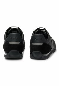 Czarne sneakersy z kombinacją teksturowanej skóry i zamszu, z gładką podeszwą i wytłoczonym logo na pięcie dla podkreślenia marki.