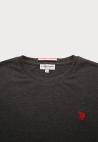 Tricou gri închis cu guler rotund, fabricat din bumbac, având un mic logo brodat cu un jucător de polo roșu pe partea stângă a pieptului. Include eticheta de mărime M.