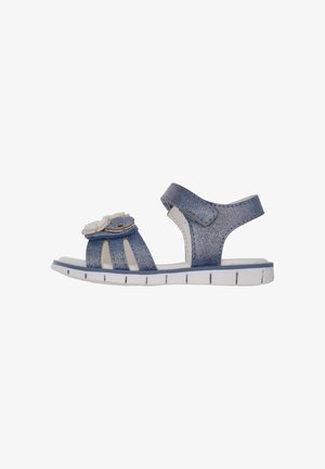 Jeans-Sandalen mit weichem blauen Stoff, offenem Zehendesign, Klettverschluss und dekorativen Blumenakzenten am Obermaterial mit weißer Sohle.