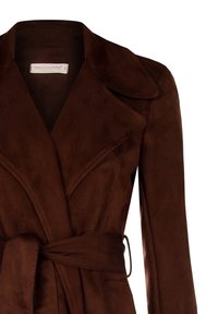 Brauner Wildleder-Trenchcoat mit breiten Revers, tailliertem Bund und langen Ärmeln. Glatte Textur; mit einem Etikett versehen, das "Rinascimento" trägt.