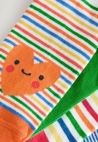 Chaussettes pour enfants avec des rayures horizontales colorées, présentant un visage de renard orange souriant sur une chaussette et une autre en vert uni.