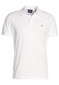 Polo shirt blanc à manches courtes avec col, patte de boutonnage à deux boutons, et petit logo GANT brodé sur la poitrine gauche.