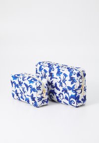 Two rectangular cosmetic bags in white fabric with blue floral patterns, featuring gold zippers, one larger and one smaller.