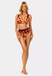 Czerwono-pomarańczowy kwiatowy bikini z szerokimi fioletowymi ramiączkami i wysokim stanem. Gładka tkanina, usztywniane miseczki i wyrazisty kontrast kolorów.
