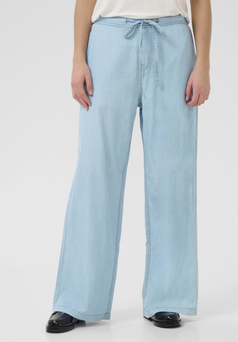Pantaloni in denim a gamba larga di colore azzurro chiaro con vita regolabile tramite cordino, caratterizzati da una texture morbida e dettagli di cucitura discreti lungo le cuciture.