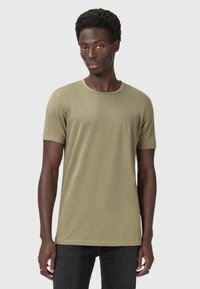 T-shirt in cotone verde oliva con scollatura rotonda, maniche corte e un piccolo logo sul petto sinistro. Silhouette aderente, texture liscia.