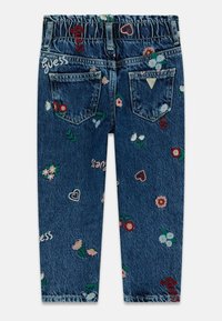 Jeans in denim con un lavaggio blu scuro, vita elastica e motivi floreali e a cuore ricamati. Presentano due tasche posteriori e branding.