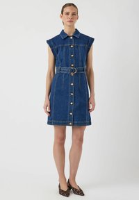 Denimkjole, blå, ermeles med krage, frontknapper, belted midje, rett snitt, synlig søm, kombinert med dyreprint sko.