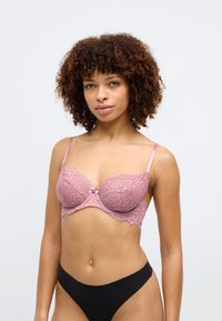 Puha rózsaszín csipke melltartó párnázott kosarakkal, vir�ágmintákkal és egy kis masni részlettel a közepén. Állítható pántok és merevítő.