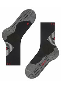 Los calcetines tobilleros en negro y gris cuentan con una suela texturizada con puntos de agarre, talón y puntera reforzados, y patrones geométricos en gris a los lados.