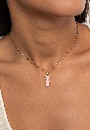 Collar de oro con un colgante de gato rosa. La cadena incluye cuentas de oro alternadas y pequeños acentos negros, con una textura delicada y fina.
