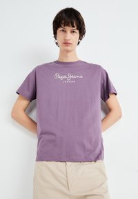 Violeta īsā piedurkne t-krekls no mīksta kokvilnas, ar baltu "Pepe Jeans London" teksta logotipu krūtīs, apaļu kakla izgriezumu un brīvu piegriezumu.