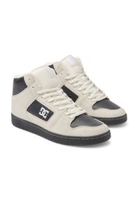 Höga sneakers med ovandel i krämfärgad mocka, svarta läderdetaljer, perforerad tå och vita snören. Har DC-logotypen på sidan.