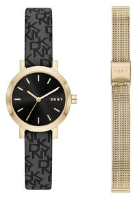 Černé hodinky DKNY s texturovaným páskem a zlatými akcenty. Mají kulatý ciferník, zlaté ručičky a na pravé straně možnost síťového pásku.