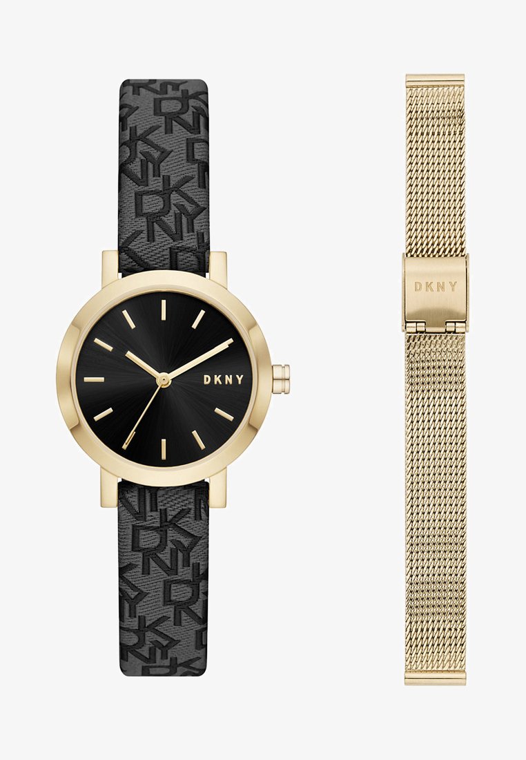 Černé hodinky DKNY s texturovaným páskem a zlatými akcenty. Mají kulatý ciferník, zlaté ručičky a na pravé straně možnost síťového pásku.