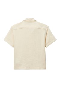 Chemise beige à manches courtes en tissu texturé, avec un col et un ourlet droit. Le dos présente un design simple et épuré, sans ornementation.