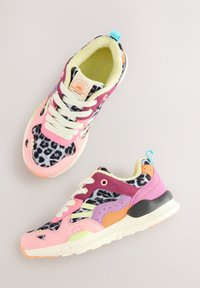 Baskets colorées avec imprimé léopard, dessus synthétique rose et violet, lacets blancs, et semelle tachetée. Dotées d'une languette de talon turquoise.