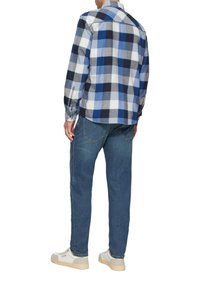 Overhemd met knoopsluiting in een blauw-wit ruitpatroon, met lange mouwen, een klassieke kraag en een afgeronde zoom, gecombineerd met een medium gewassen spijkerbroek en lichte sneakers.