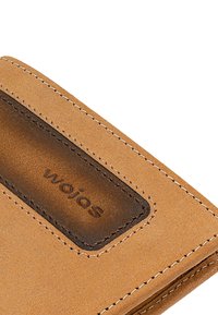 Portafoglio in pelle marrone con texture liscia, cuciture a contrasto e un'area di accento marrone scuro con nome del marchio impresso.