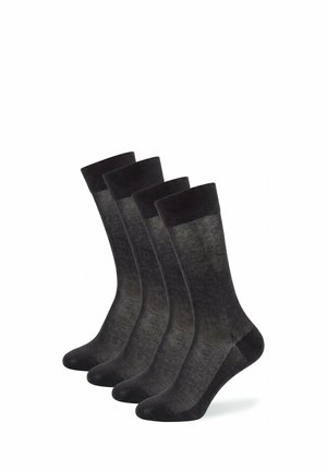 Vier paar zwarte sokken tot halverwege de kuit met geribde boordjes, gerangschikt in een verspringende rij op een witte achtergrond.