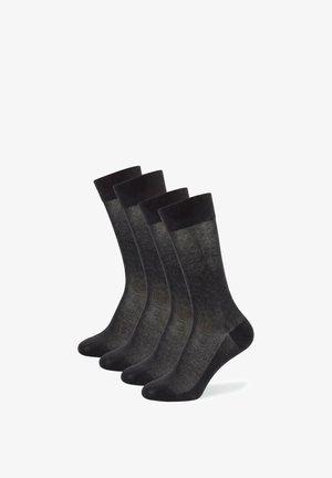 Vier Paar schwarze Mid-Calf-Socken mit gerippten Bündchen in einer versetzten Reihe auf weißem Hintergrund angeordnet.