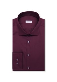 Chemise à manches longues pliée en violet foncé avec des boutons sur le devant et sur le poignet, avec un col classique et une étiquette de marque à l'intérieur.