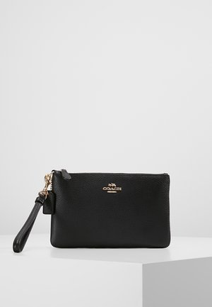 Black pebbled leather wristlet clutch with gold Coach logo and detachable strap, displayed on a white surface against a plain background.