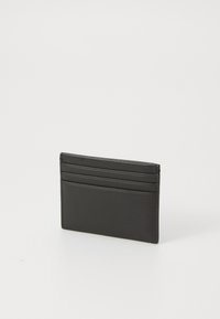 Portofel de carduri din piele neagră, cu patru sloturi, formă rectangulară elegantă, textură netedă și design minimalist.