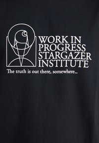 T-shirt preta de algodão com texto gráfico branco: "INÍCIO DE TRABALHO INSTITUTO STARGAZER" e "A verdade está lá fora, em algum lugar..."
