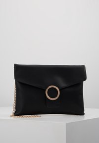 Svart clutch-väska i slät läder med en vikbar design, prydd med en guldfärgad ringdetalj och en kedjestropp.