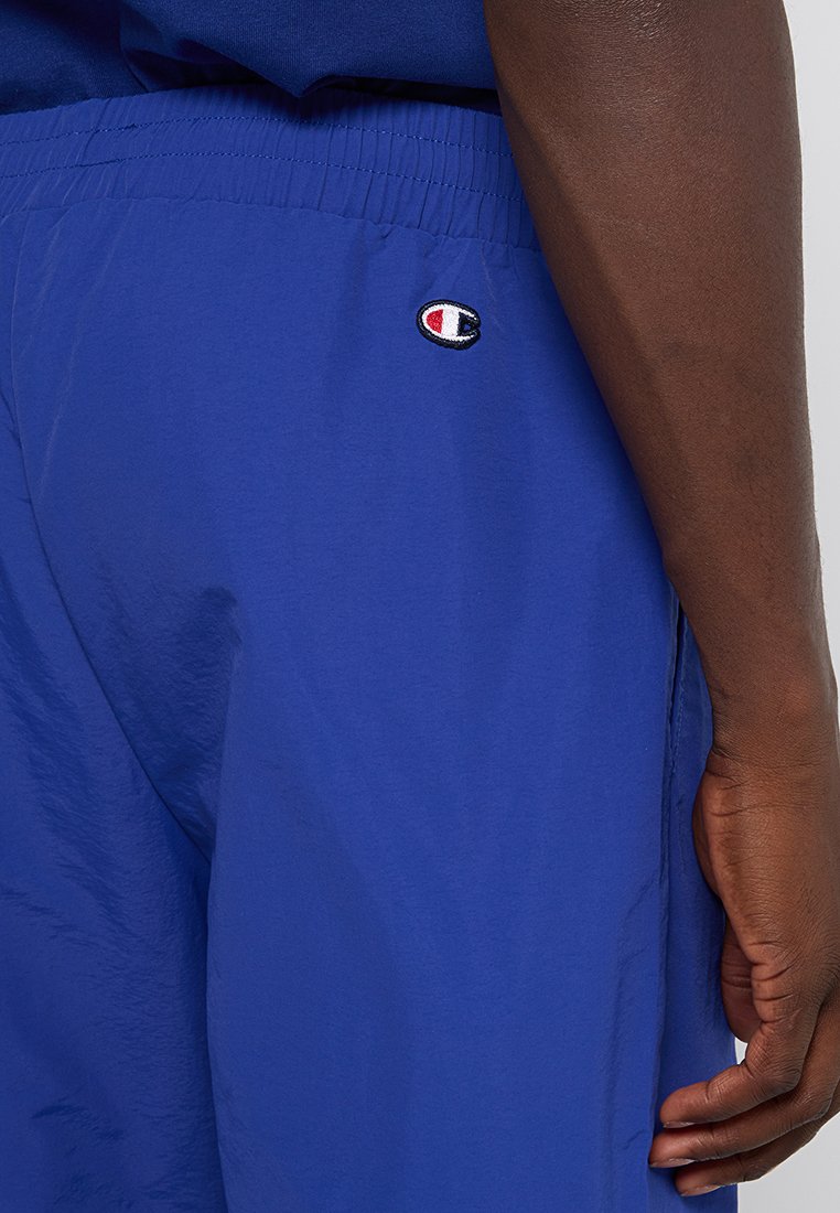 Shorts de sport bleus en matériau léger, dotés d'une taille élastique et d'un petit logo brodé à l'arrière.