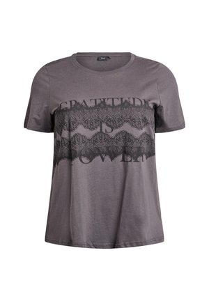 Grå bomulls t-shirt med korta ärmar, med ett svart spetsmönster och texttryck som säger "TACKSAMHET ÄR KRAFT" över bröstet.