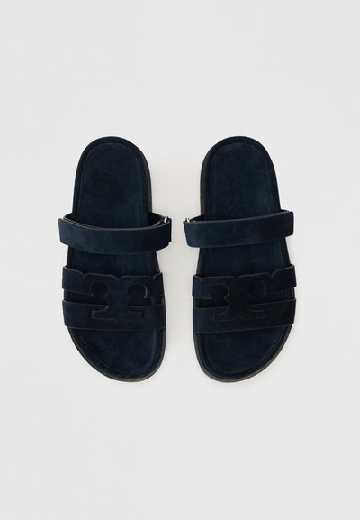 Marineblå ruskinds slidesandaler med dobbelte stropper og udskæringsdetaljer, flad sål og blød tekstur. Designet til afslappet brug.