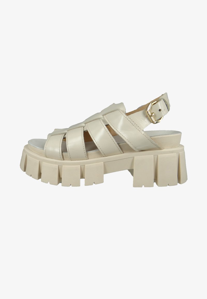 Beige strappy sandal with chunky ridged sole, made of shiny material, featuring an adjustable buckle and open toe design.