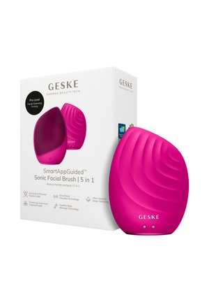 Felroze GESKE sonische gezichtsborstel met een getextureerd oppervlak naast de witte doos die de 5-in-1 functies voor diepe reiniging en versteviging benadrukt.