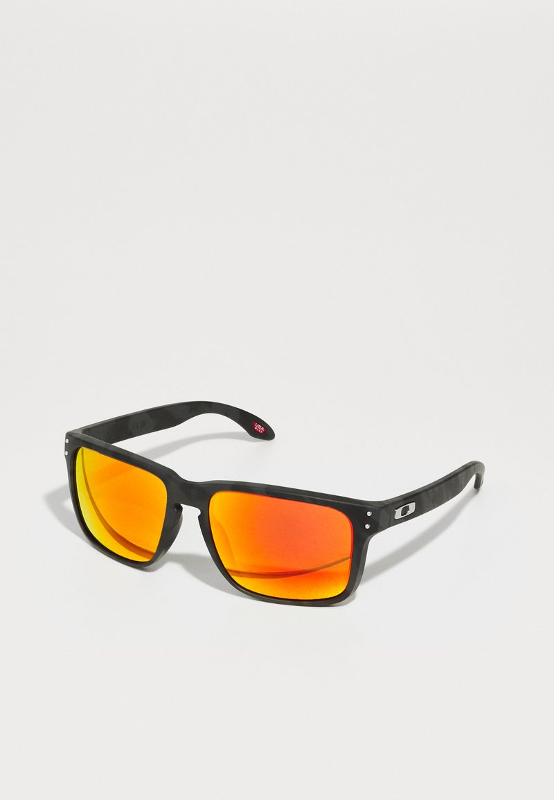 Ochelari de soare din plastic negru cu lentile reflectorizante portocalii, formă rectangulară largă, accent metalic aproape de balamale și brațe curbate.